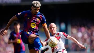 Piłkarz FC Barcelony w akcji z piłką, walczący o nią z przeciwnikiem.