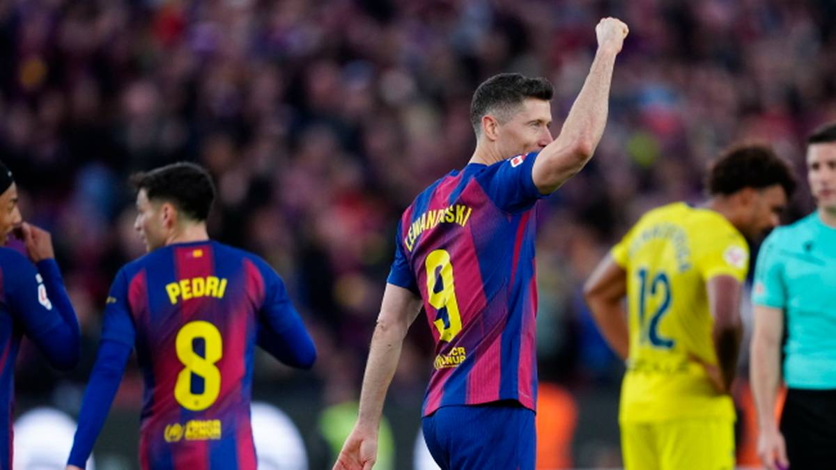 Piłkarz Robert Lewandowski w koszulce FC Barcelony z numerem 9 cieszy się po zdobyciu bramki, obok niego stoi Pedri w koszulce z numerem 8.