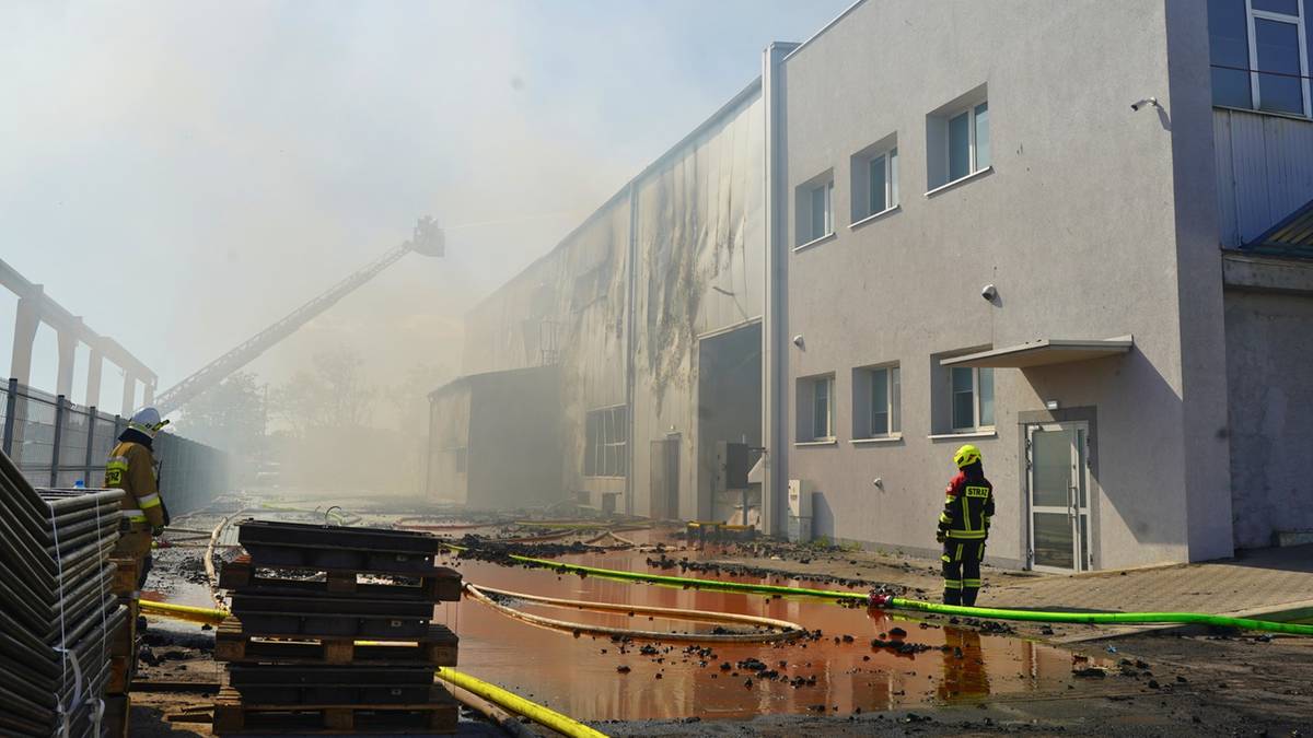 Strażacy gaszą pożar hali produkcyjnej w Obornikach, widoczny dym i sprzęt gaśniczy.