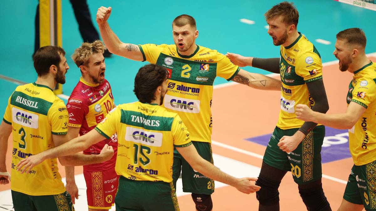 Siatkarze w żółto-zielonych strojach świętujący na boisku.