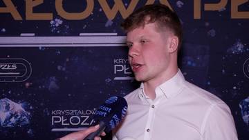 Mężczyzna w białej koszuli rozmawia z dziennikarzem, trzymając mikrofon.