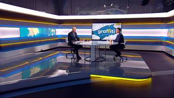 Dw&oacute;ch mężczyzn siedzi przy okrągłym stole w studiu telewizyjnym. Na monitorze wyświetla się napis "graffiti".