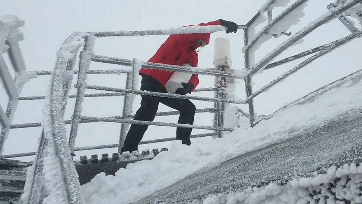 Obserwator meteo na tarasie WOM na Śnieżce wymienia deszczomierz. Fot. IMGW-PIB.