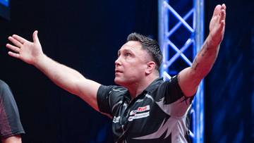 Gracz rzuca lotką do tarczy.