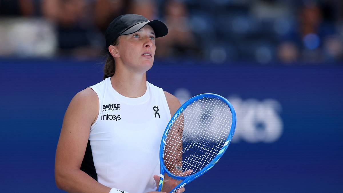 Iga Świątek podczas meczu tenisowego, z rakietą w ręku i skupionym wyrazem twarzy.