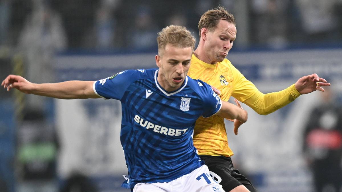 Dwóch piłkarzy walczy o piłkę na boisku podczas meczu piłki nożnej.