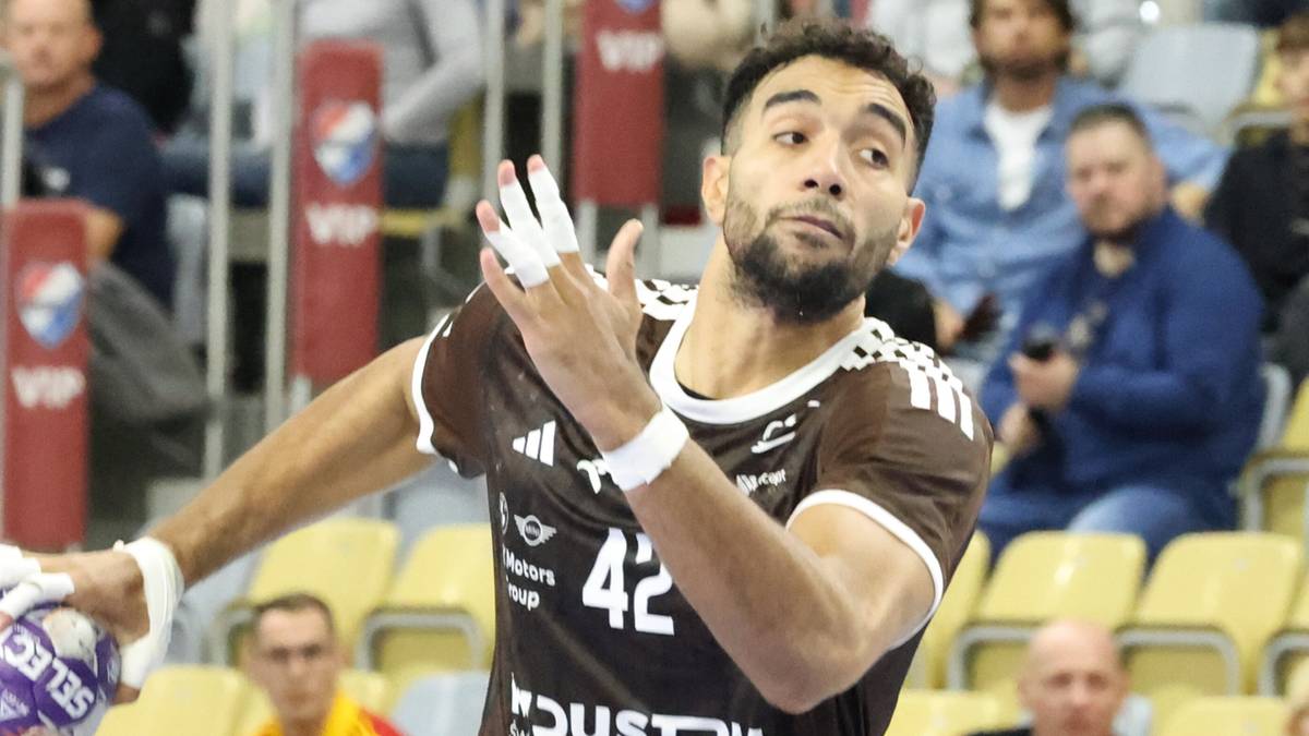 Gracz piłki ręcznej w brązowej koszulce z numerem 42 wykonuje rzut podczas meczu.