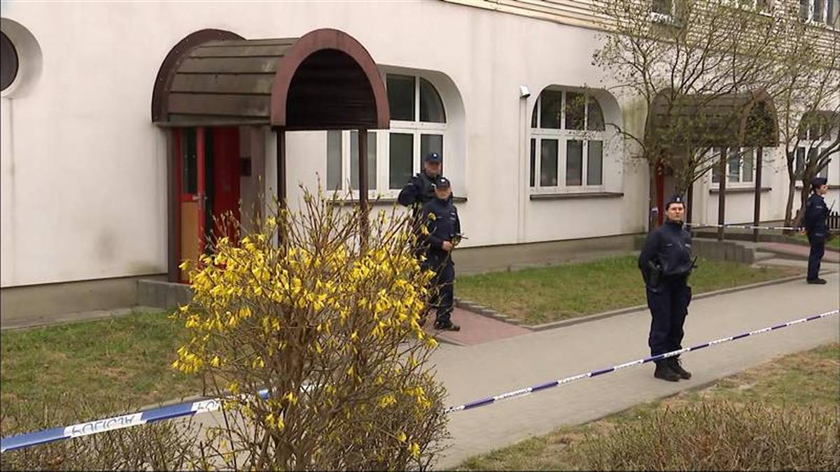 Budynek mieszkalny z policjantami i taśmą policyjną zabezpieczającą teren.