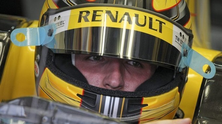 Zbliżenie na twarz Roberta Kubicy w kasku zespołu Renault.