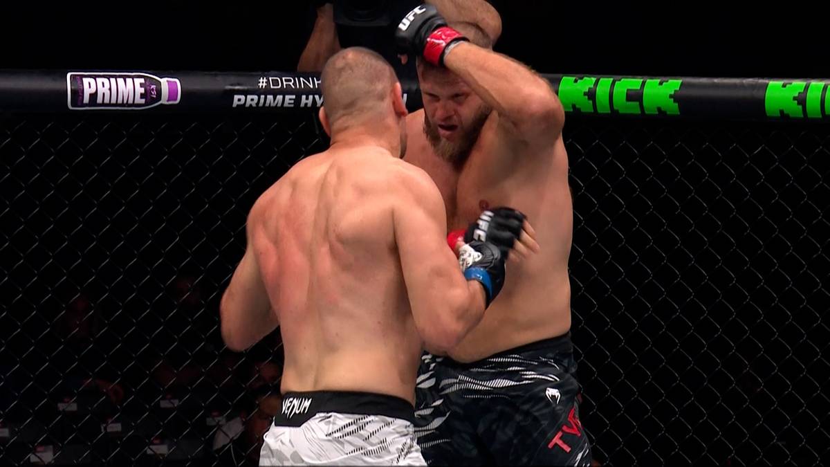 Dwóch zawodników MMA walczących w ringu, jeden zawodnik klęka z powodu ciosu.