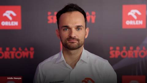 Portret Bartosza Zmarzlika, polskiego żużlowca, w białej koszuli z logo Orlen. W tle czerwone napisy "Przegląd Sportowy" i "Polsat Sport".