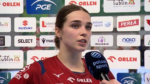 Marcelina Polańska, zawodniczka w czerwonej koszulce, udziela wywiadu na tle ścianki sponsorskiej.