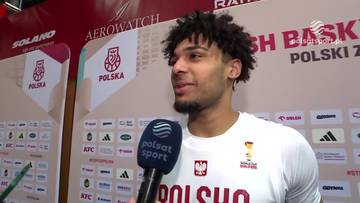 Mężczyzna udziela wywiadu, ubrany w koszulkę z napisem POLSKA, z logotypami sponsorów w tle.