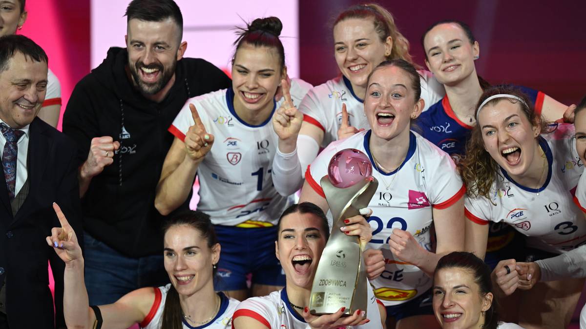 Grupa uśmiechniętych siatkarek PGE Budowlanych Ł&oacute;dź świętujących zwycięstwo w Pucharze Polski, trzymających puchar.