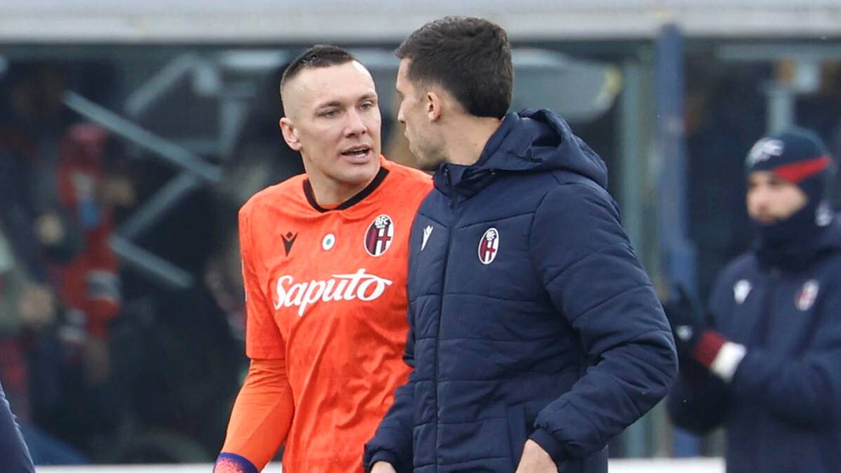 Grupa piłkarzy w niebiesko-czerwonych strojach schodzi z boiska, jeden z nich ma założone rękawice bramkarskie.