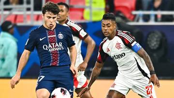 Dw&oacute;ch piłkarzy w akcji na boisku piłkarskim, jeden w granatowej koszulce PSG z napisem Qatar, drugi w białej koszulce Flamengo.