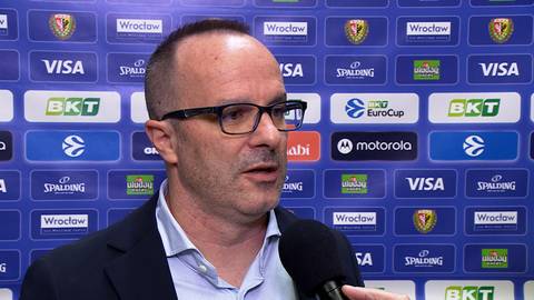 Diego Ocampo, mężczyzna w okularach, ubrany w koszulę i marynarkę, udziela wywiadu na tle ściany z logotypami sponsor&oacute;w.