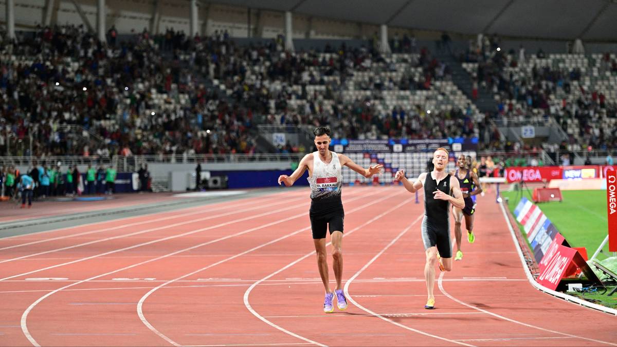 Dw&oacute;ch biegaczy na bieżni stadionu lekkoatletycznego.