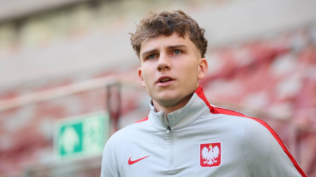 Młody piłkarz w dresie reprezentacji Polski z herbem i logo sponsora