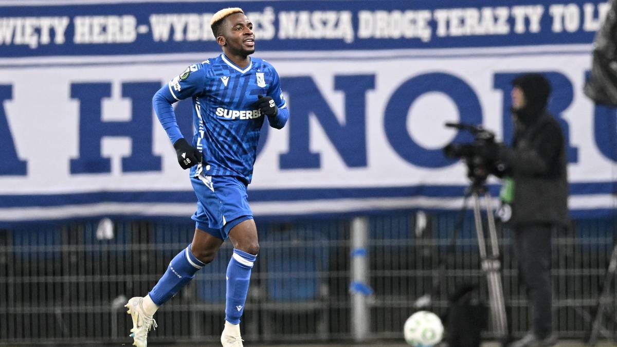 Piłkarz Lecha Poznań w niebieskim stroju biegnie po boisku.