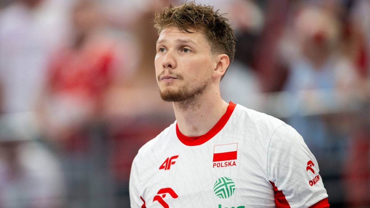 Portret siatkarza w białej koszulce z flagą Polski.