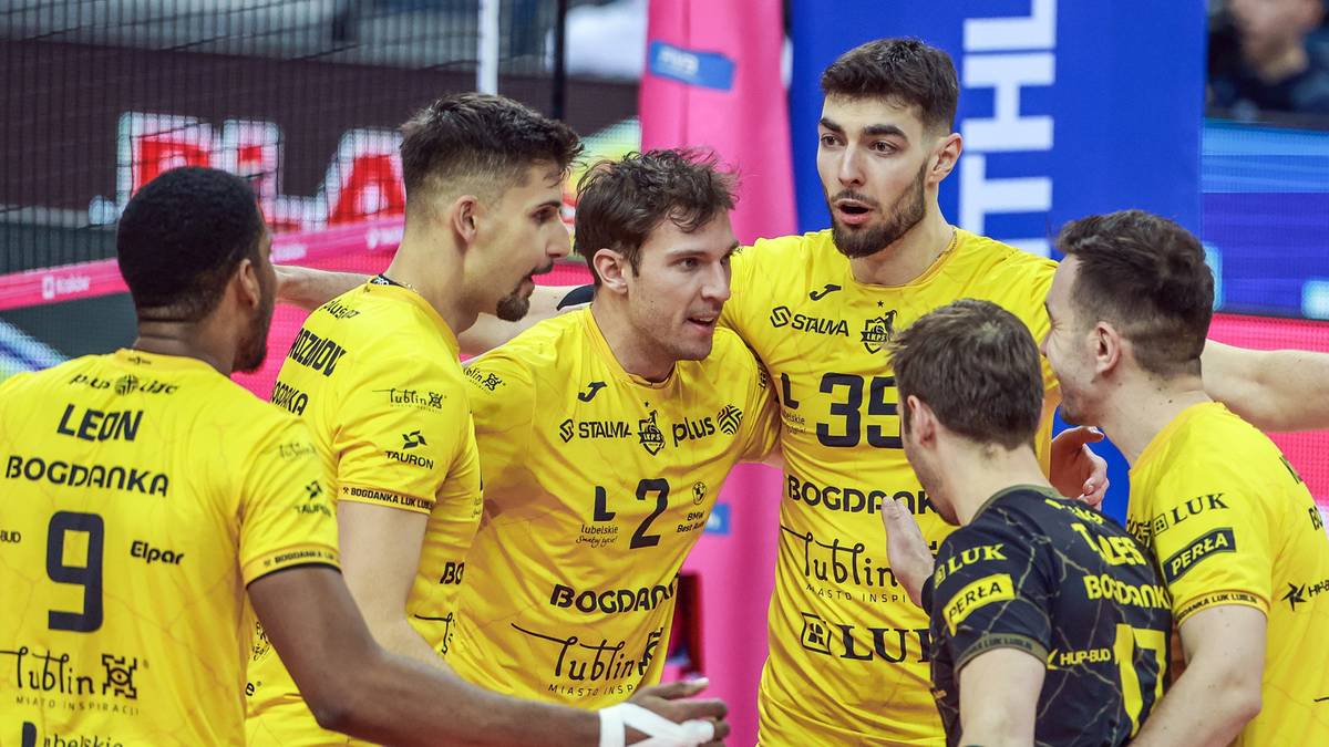 Siatkarze w żółtych strojach drużynowych, skupieni w grupie.