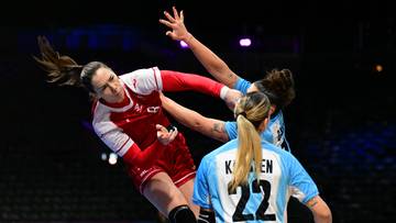 Trzy zawodniczki piłki ręcznej w akcji, jedna próbuje rzucić, dwie bronią.