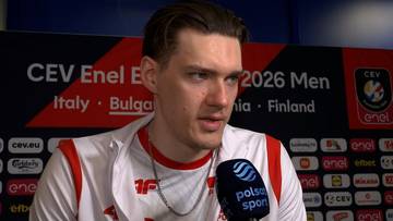 Bartłomiej Lemański udziela wywiadu przed ścianką sponsorską w stroju reprezenta