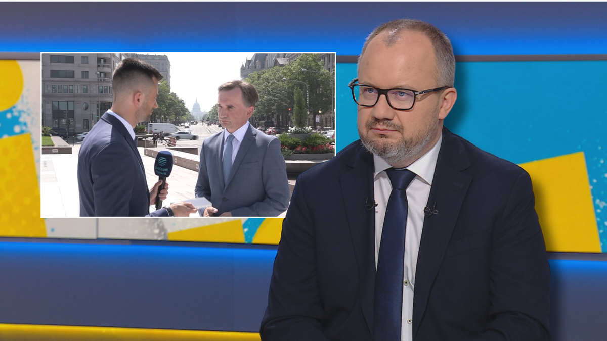 Mężczyzna w garniturze i okularach siedzi na tle ekranu z fragmentem nagrania,"na którym dwaj inni mężczyźni rozmawiają z reporterem na ulicy.