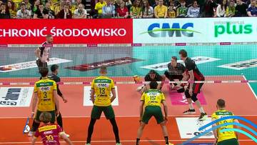 Zawodnicy drużyny siatkarskiej w akcji podczas meczu, jeden z nich wykonuje zagranie z piłką.