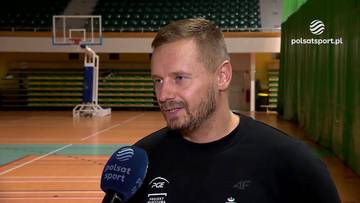 Damian Wojtaszek udzielający wywiadu w hali sportowej na tle boiska.