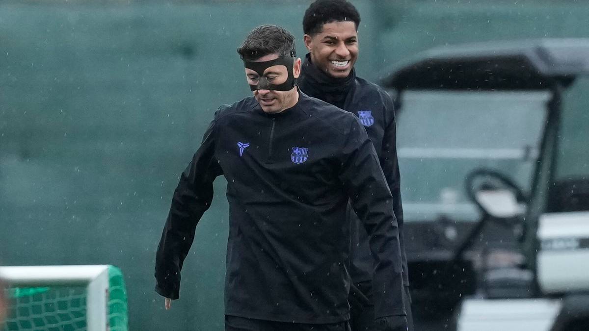 Piłkarz w czarnej masce ochronnej na twarzy i w czarnym stroju sportowym.