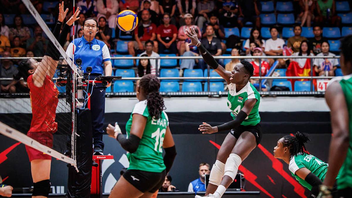 Siatkarka w zielonej koszulce odbija piłkę do zagrywki, w tle inny zawodnik i sędzia.