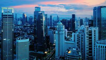 Panorama nowoczesnego miasta z wysokimi drapaczami chmur o zachodzie słońca.