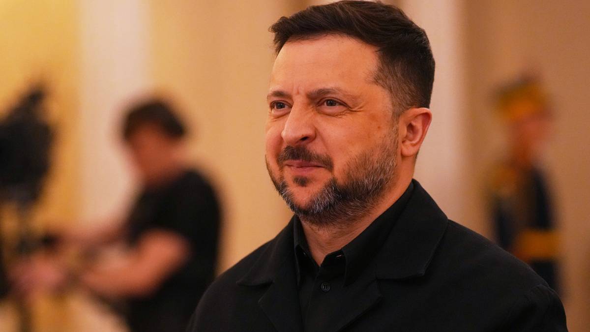 Wołodymyr Zełenski, prezydent Ukrainy, w czarnym ubraniu, z zarostem, patrzy w bok.
