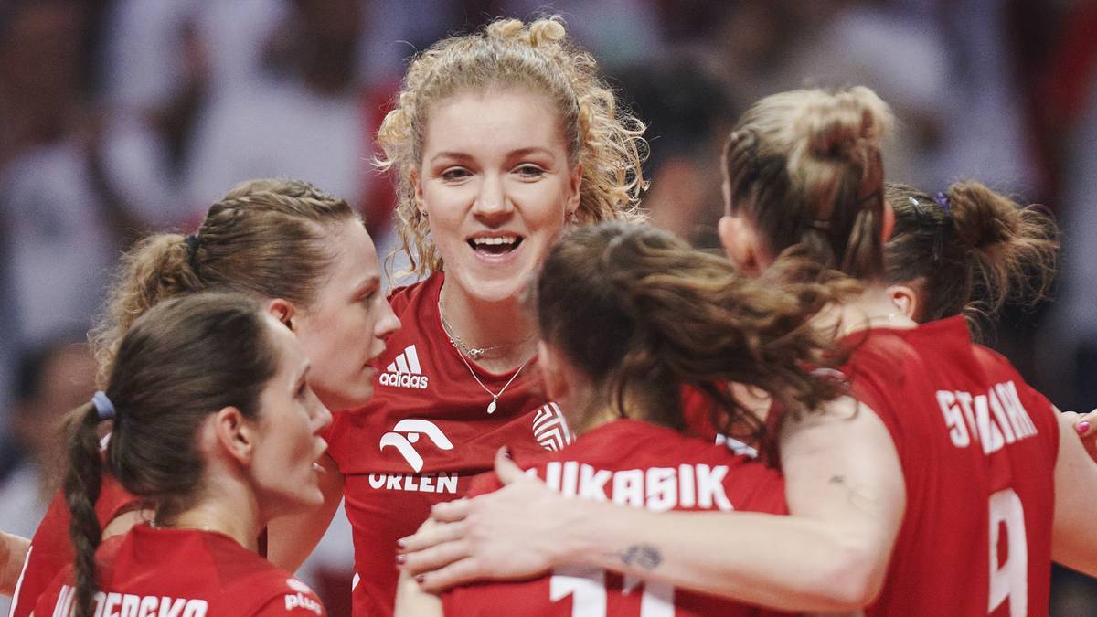 Grupa polskich siatkarek w czerwonych strojach świętuje zwycięstwo, obejmując się nawzajem.