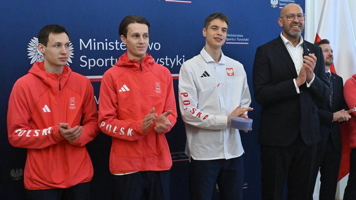 Trzech młodych polskich sportowc&oacute;w stoi obok ministra sportu, kt&oacute;ry im gratuluje.