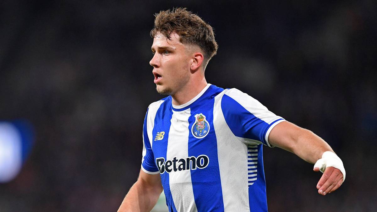 Młody piłkarz w biało-niebieskiej koszulce FC Porto z nazwiskiem na piersi "Betano", patrzy w bok z lekko otwartymi ustami.