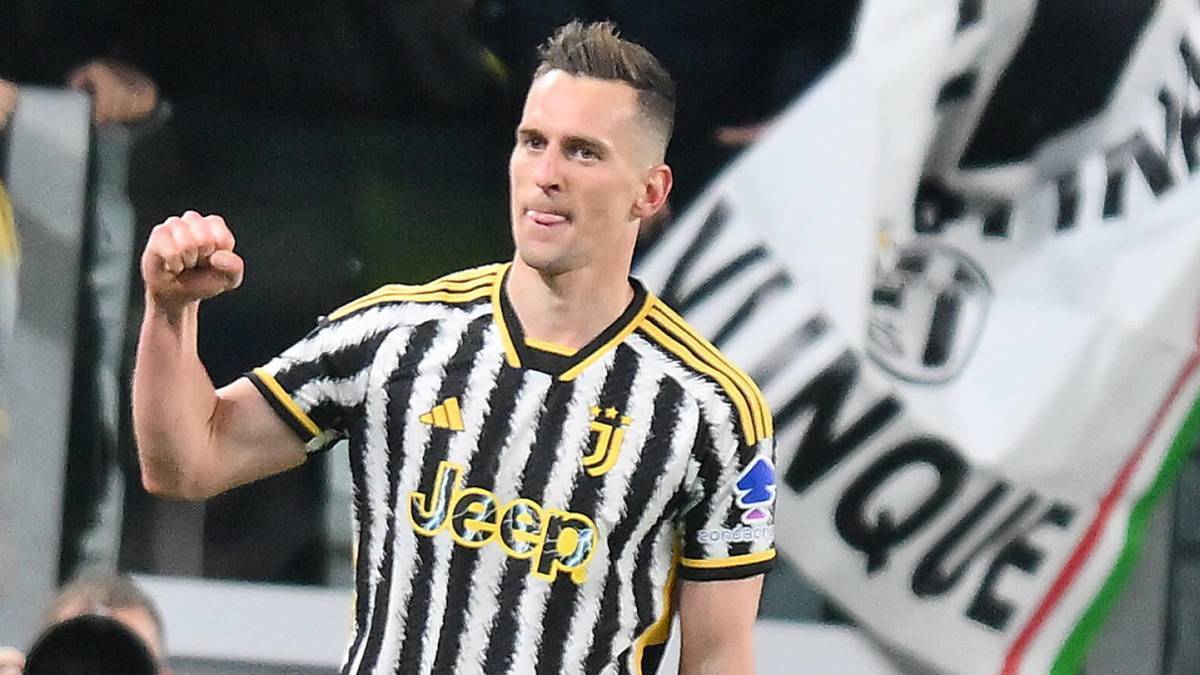 Piłkarz Arkadiusz Milik w koszulce Juventusu z podniesioną pięścią w geście radości lub motywacji.