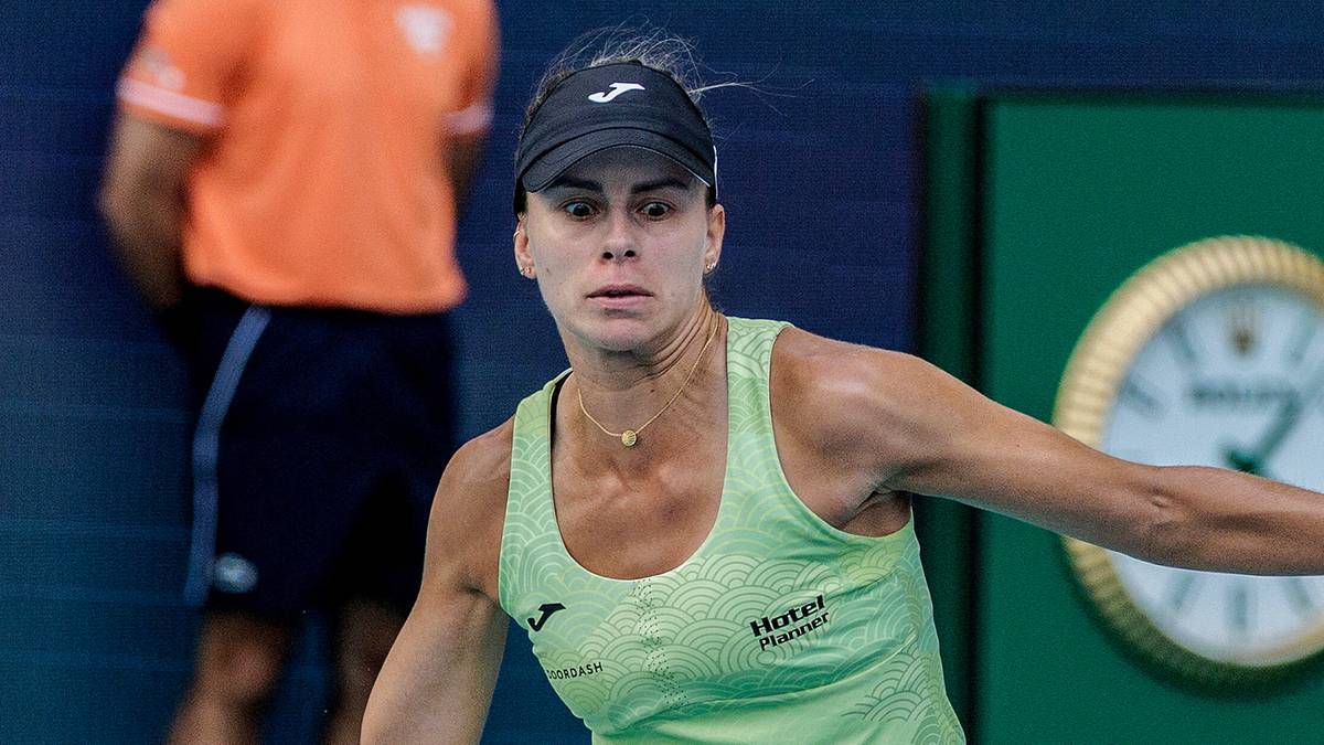 Kobieta tenisistka w neonowo-żółtej koszulce i czarnej opasce na głowie, patrząca z determinacją przed siebie podczas meczu.