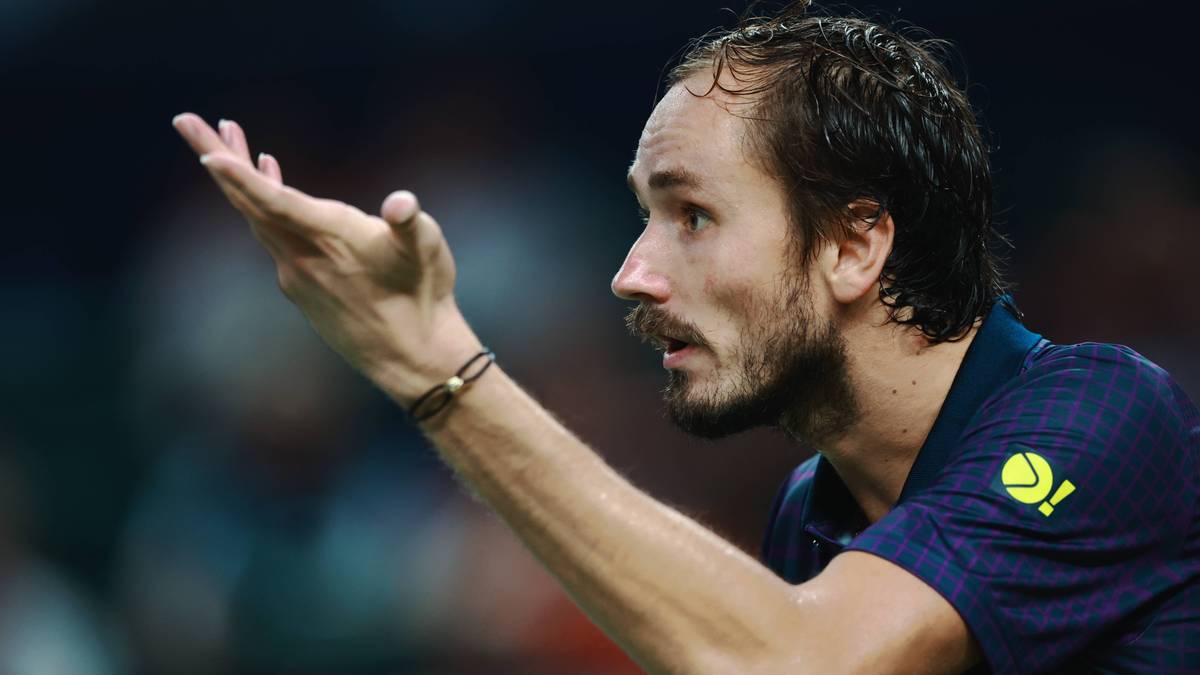 Tenisista Daniil Medvedev podczas meczu, zwrócony profilem w prawo, z uniesioną ręką.