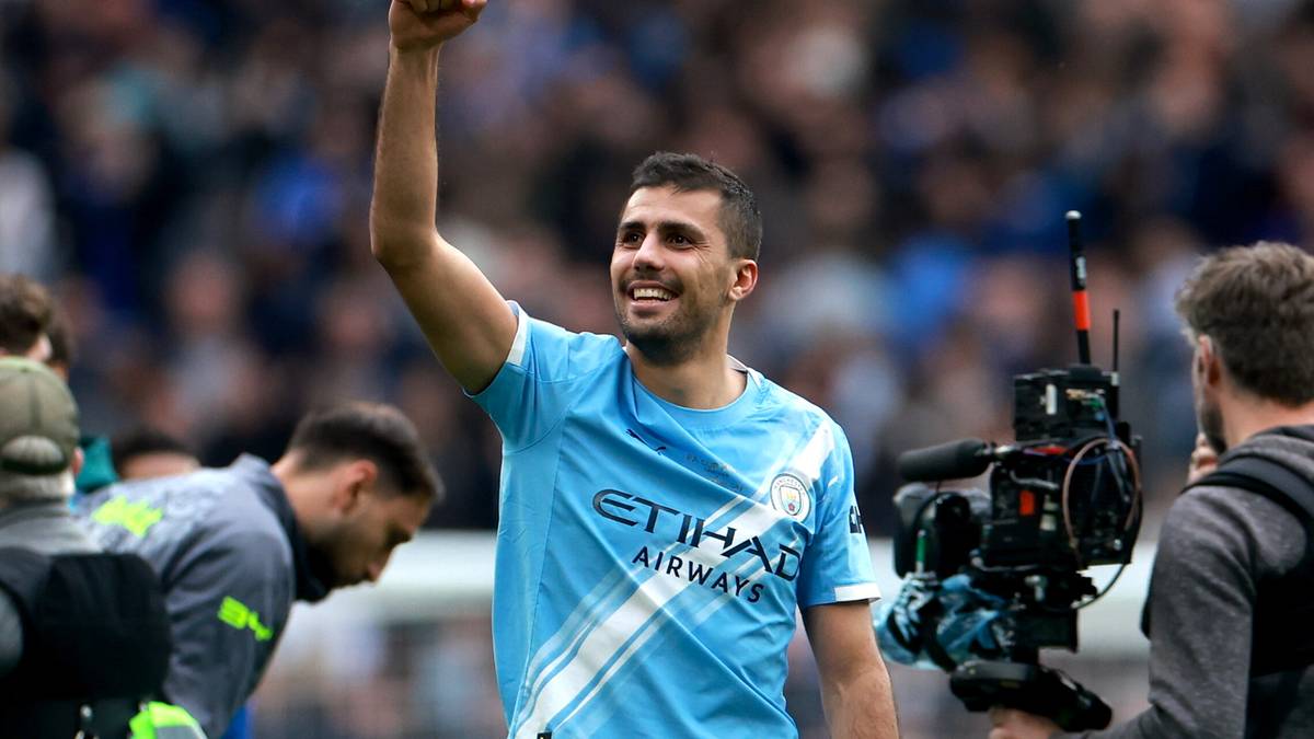 Piłkarz Manchesteru City świętujący zwycięstwo z podniesioną ręką.