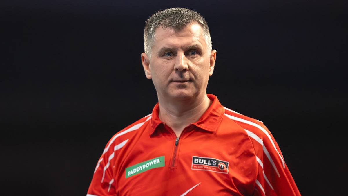 Portret Krzysztofa Ratajskiego w czerwonej koszulce sportowej.