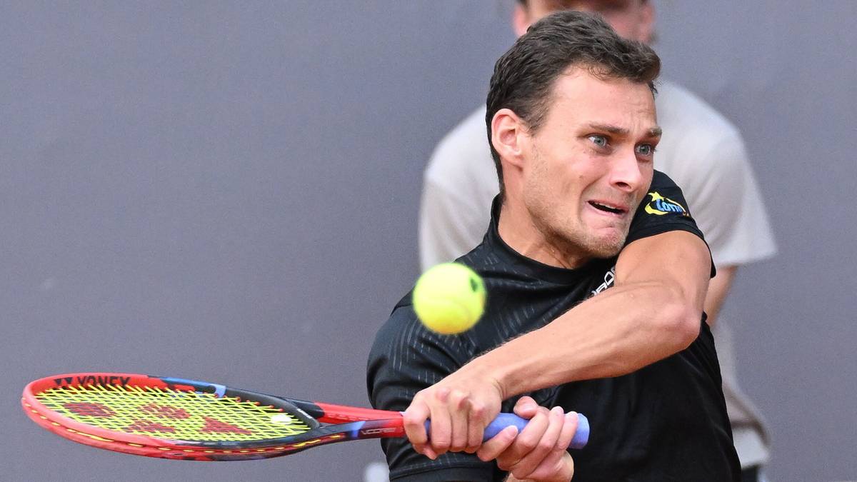 Tenisista z determinacją uderza piłkę rakietą podczas meczu.