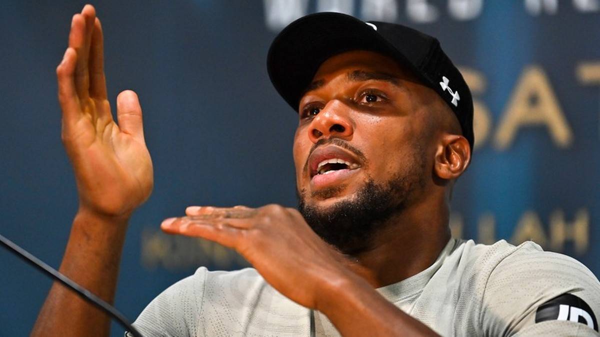 Anthony Joshua, bokser, podczas konferencji prasowej, gestykuluje.