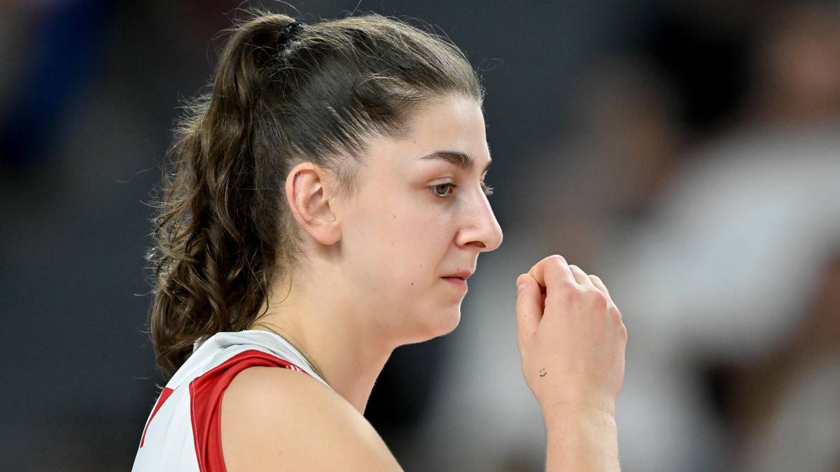 Portret siatkarki Martyny Łukasik z profilu, z włosami związanymi w kucyk. Ma na sobie białą koszulkę z czerwonymi elementami.