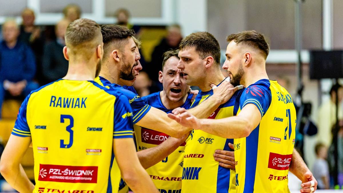Grupa siatkarzy w ż&oacute;łto-niebieskich strojach w trakcie meczu, z numerami na plecach