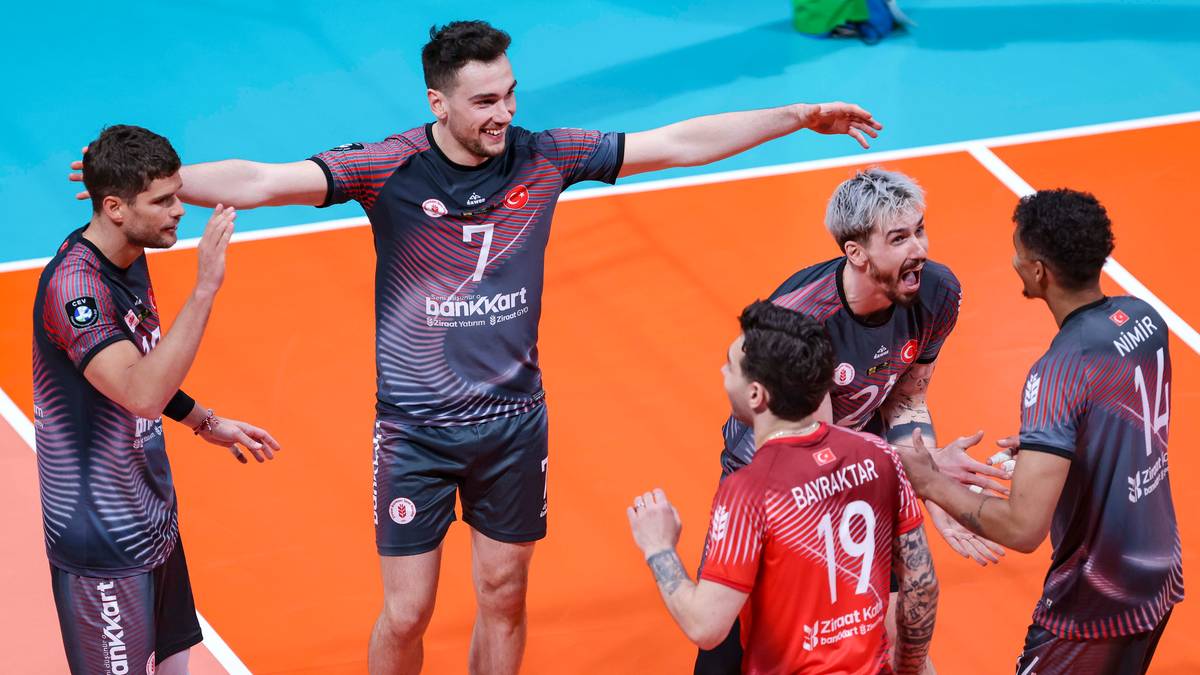 Siatkarze w strojach sportowych cieszą się ze zwycięstwa na boisku siatkarskim.