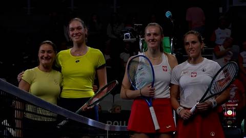 Cztery tenisistki pozują do zdjęcia, dwie w żółtych i dwie w białych strojach, trzymając rakiety tenisowe.