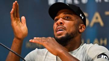 Anthony Joshua, bokser, podczas konferencji prasowej, gestykuluje.
